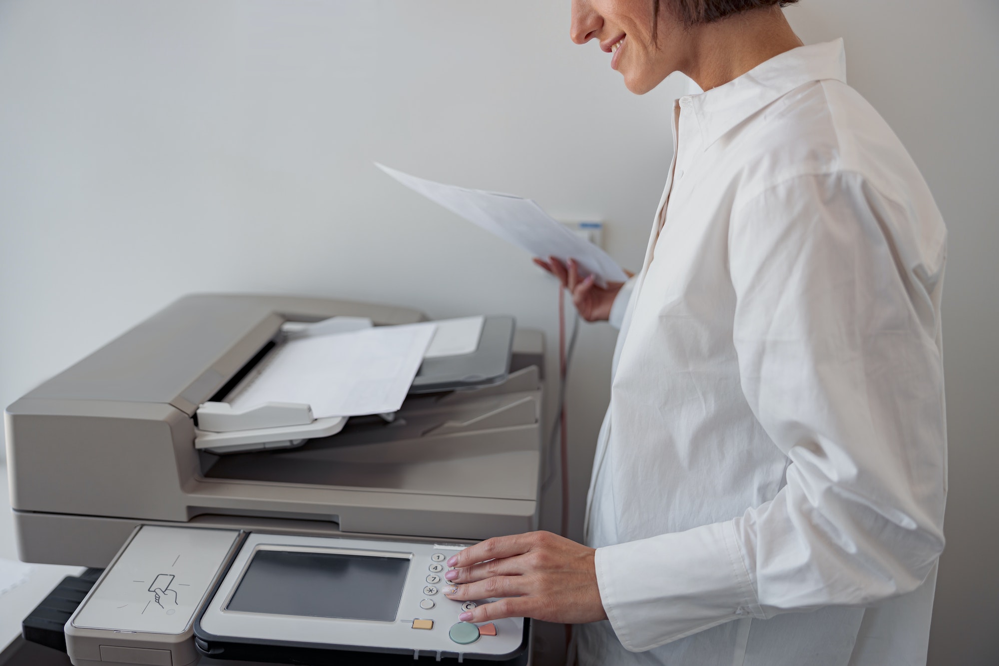 Close up of woman worker scanning a document on photocopy machine In modern office